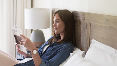 Middle-aged-Caucasian-woman-enjoys-reading-in-bed-at-home