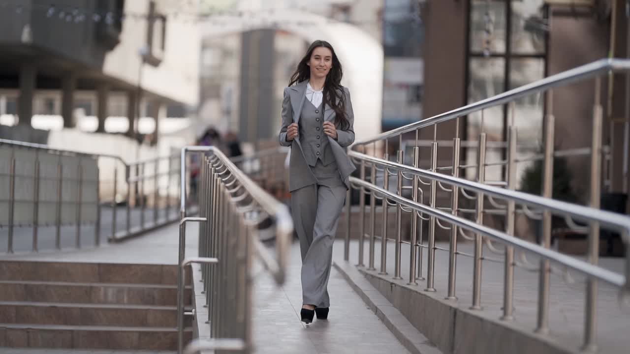 Stylish young woman in a business suit threesome walking the city model gait