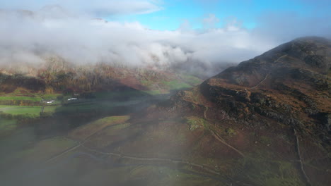 Sie-Tauchen-Aus-Den-Wolken-Auf-Und-Zeigen-Berghänge,-Grüne-Täler-Und-Wolkenverhangene-Berge,-Die-Von-Der-Herbstsonne-Am-Frühen-Morgen-Beleuchtet-Werden