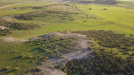 Aerial-shot-of-a-green-valley-behind-small-hills