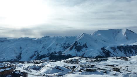 a view of majestic snow-capped mountains under a soft, cloudy sky, capturing the peaceful beauty of the winter wilderness