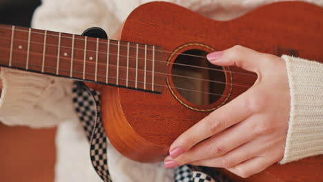 the hands of an unrecognizable girl playing the ukelele 1