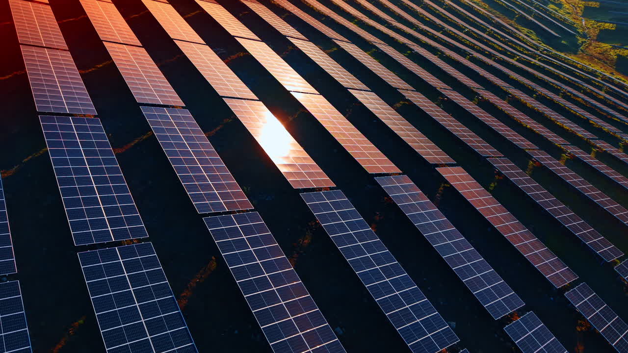 Solcellepaneler dekket av det gylne lyset fra den nedgående solen. Solceller absorberer sollys. Droneopptak