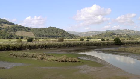 Drone-flyover-River-estuary-in-Santona,-Scenic-Marshes-on-Sunny-day,-Spain