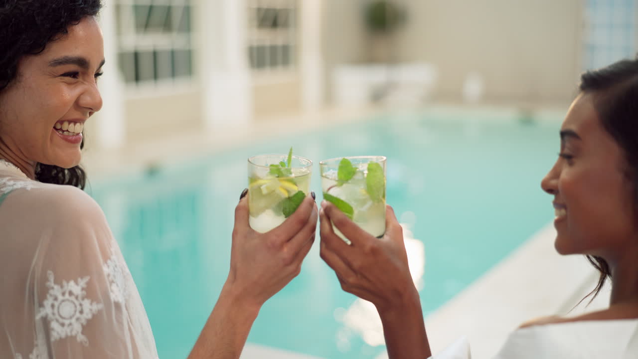 Women enjoying cocktails by the pool