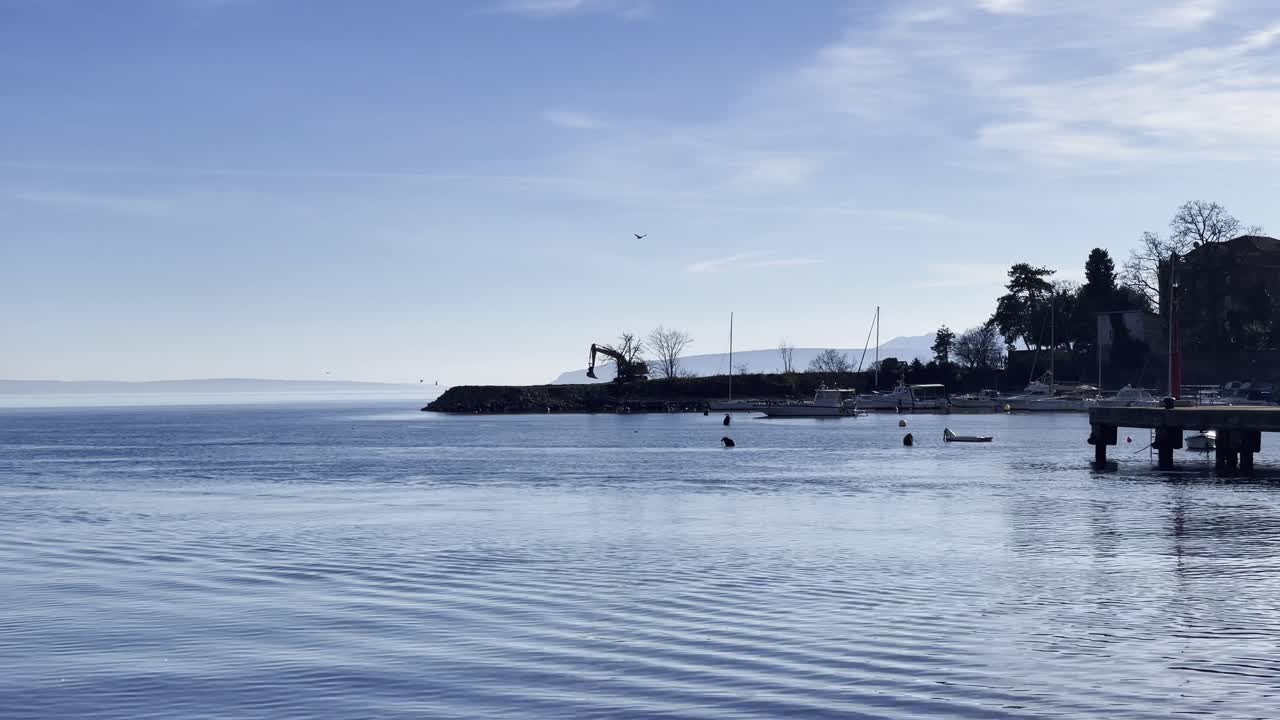 크로아티아의 아파티야 (opatija) 에서 멀리 있는 섬과 함께 마리나 (marina) 의 바가에 주차된 발굴기