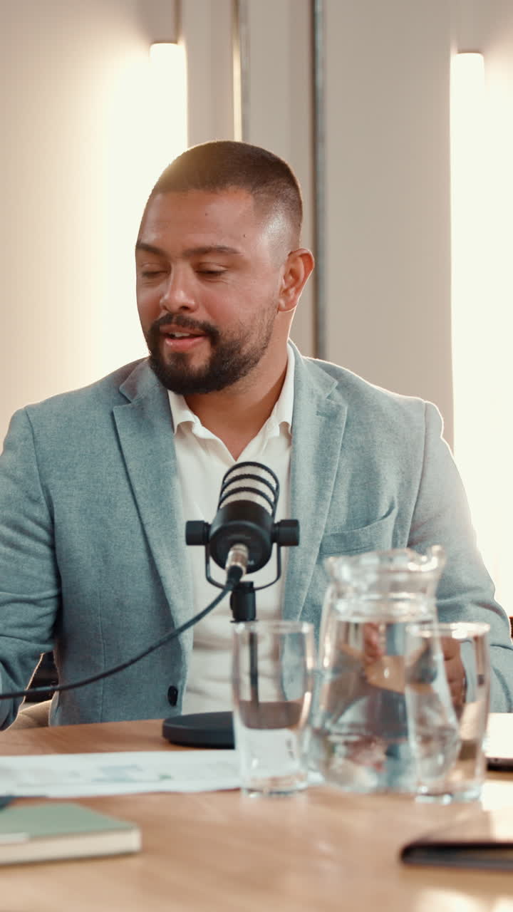 Man recording a podcast with a microphone and a pitcher of water
