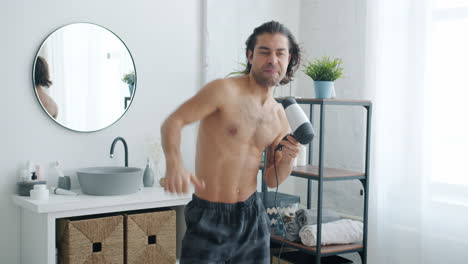 man dancing in bathroom with hair dryer