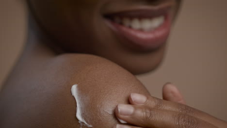 woman applying cream to shoulder