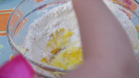 Childs-POV,-close-up-of-a-bowl-of-cake-mix-being-beaten-by-a-small-girl,-on-a-patio-table-in-daytime