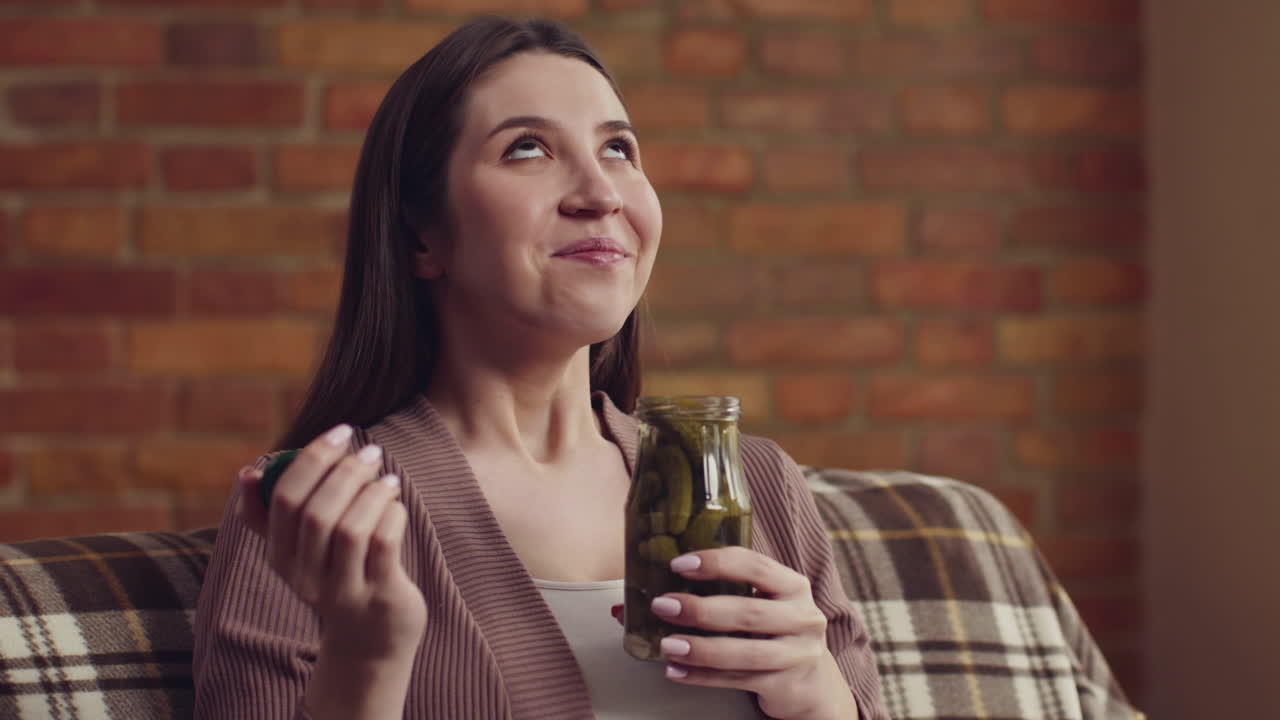 una mujer disfrutando de un frasco de pepinillos