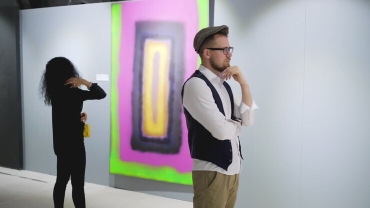 Visitantes de galeria de arte observando pintura abstrata