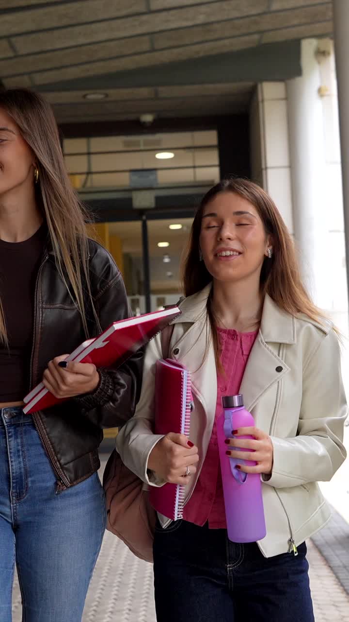 Giovani studentesse felici che camminano e parlano nel campus universitario