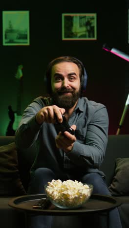 vertical video ecstatic man gaming at home yelling from joy after achieving victory