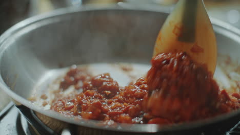 mezclar tomates y cebollas picadas en una sartén caliente con una espátula