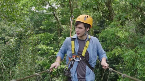 man passing the cable route high among trees