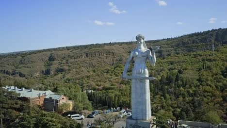 tbilisi aerial view on a kartlis deda monument , autumn view, no sun, cars passing by, old town, glass bridge