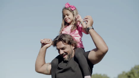 medium shot of happy caucasian father putting kid on neck