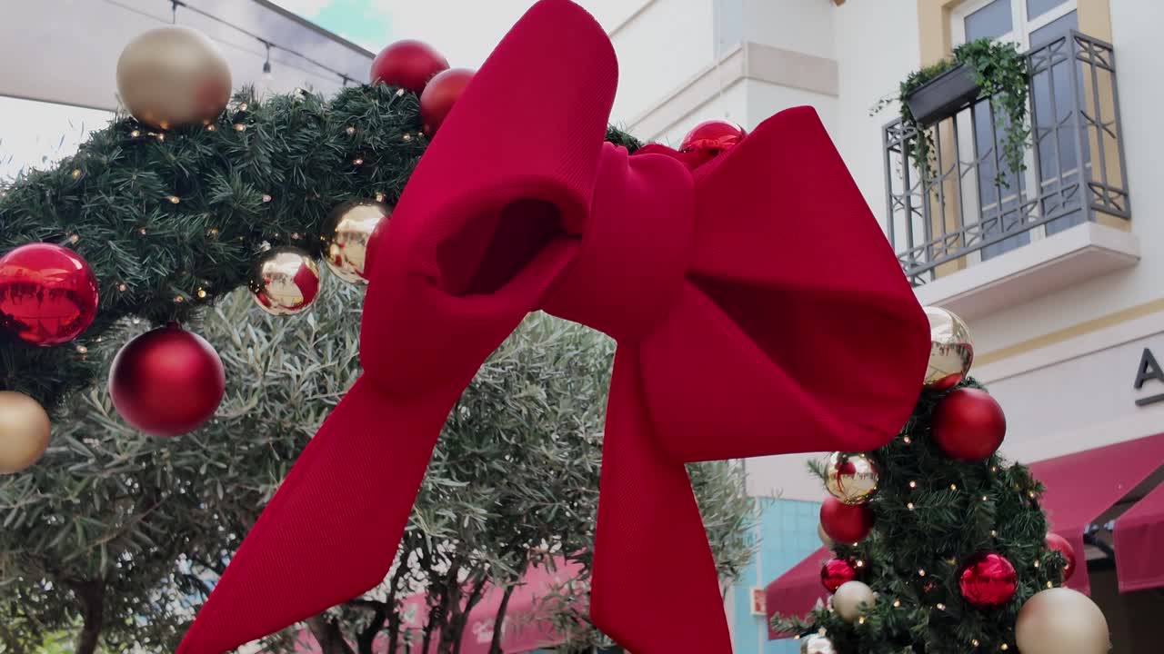 Christmas ornament arrangement centered around a big red bow for a cheerful seasonal look