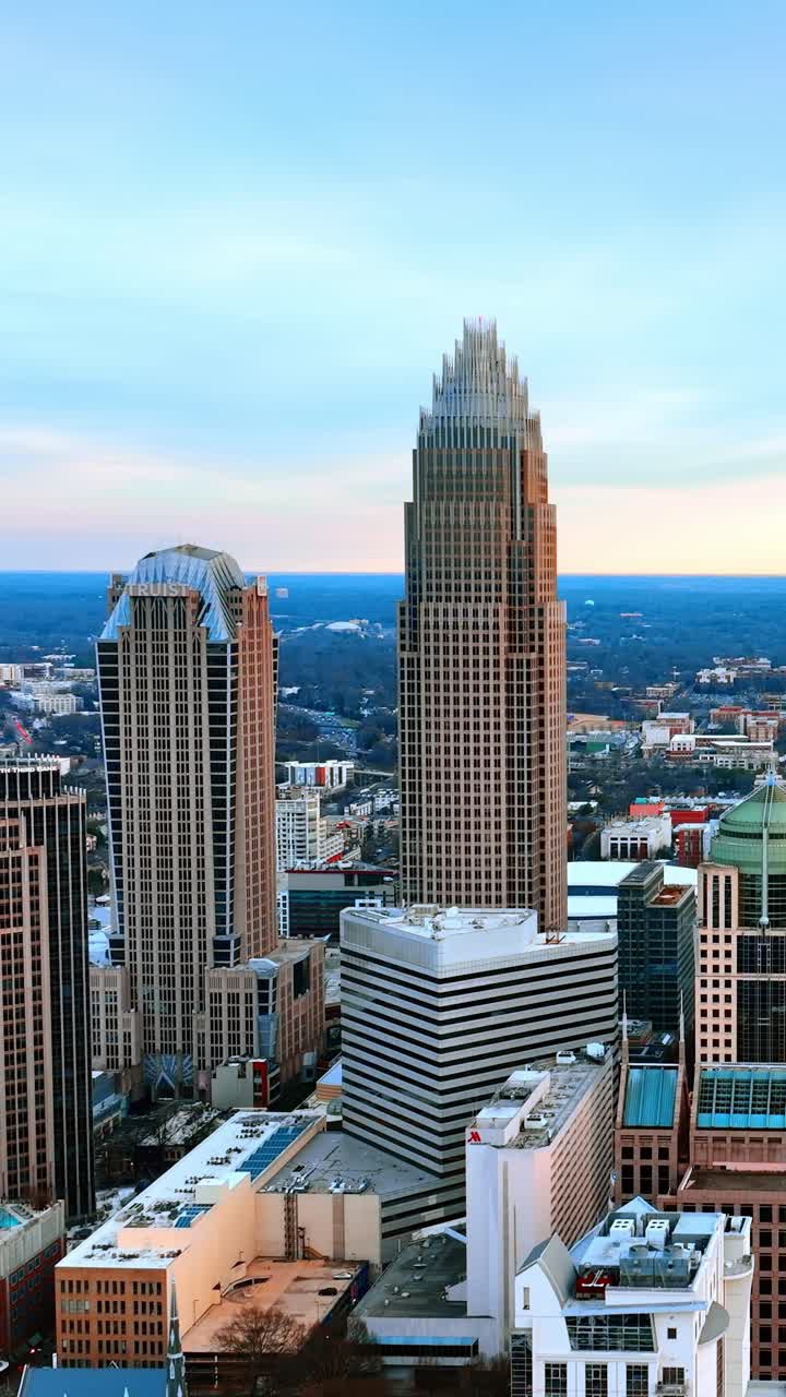 Bellissimo centro di Charlotte, Carolina del Nord, USA. Drone che si alza lungo i moderni grattacieli sullo sfondo di un cielo blu. Video verticale