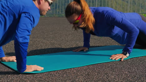 couple doing push-ups outdoors