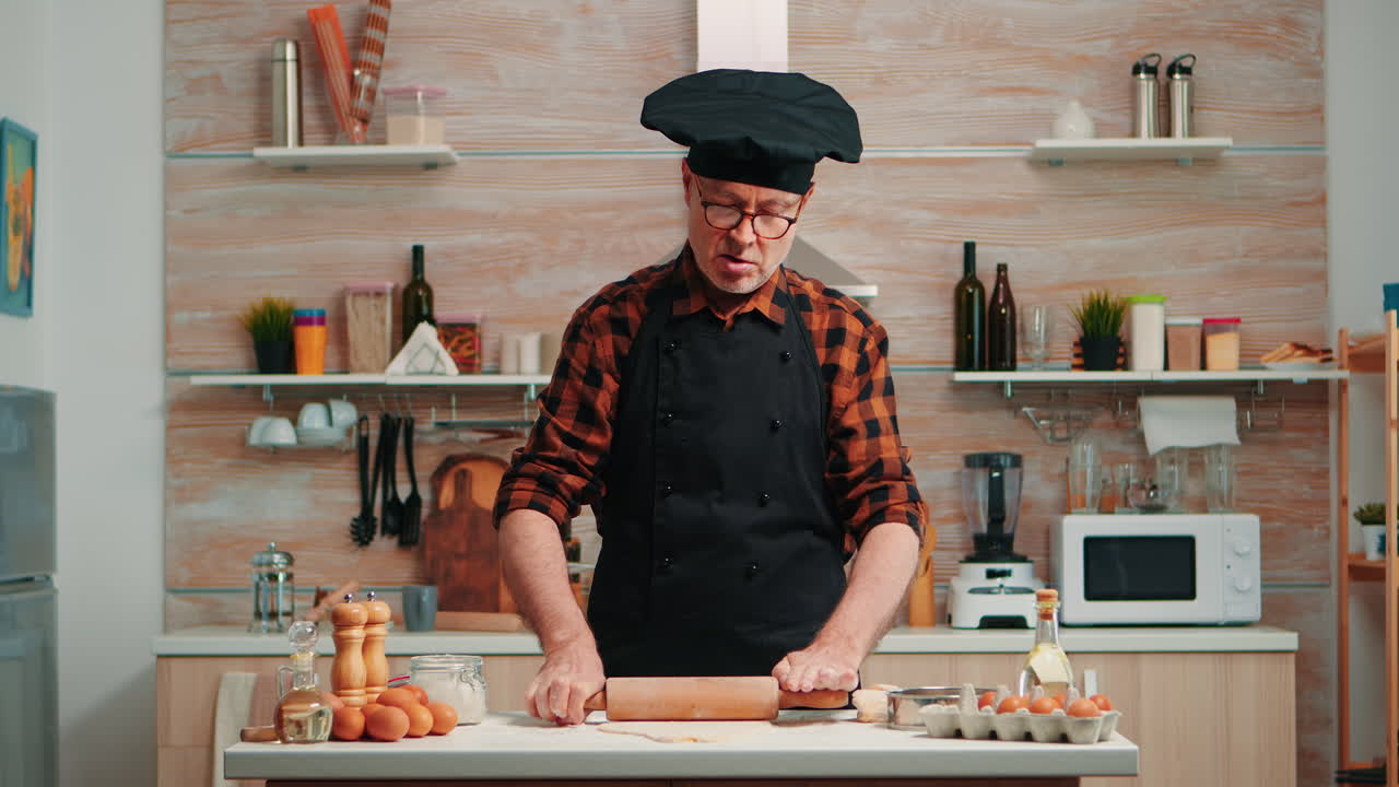 hombre maduro preparando pizza en la mesa de la cocina