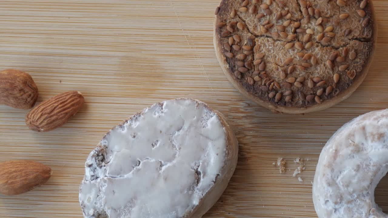 Panning view of traditional Spanish Christmas sweets, polvorones. Almonds, doughnuts, butter on a table. Close-up