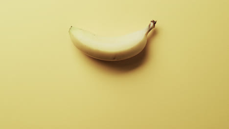 Video-of-banana-with-copy-space-over-yellow-background