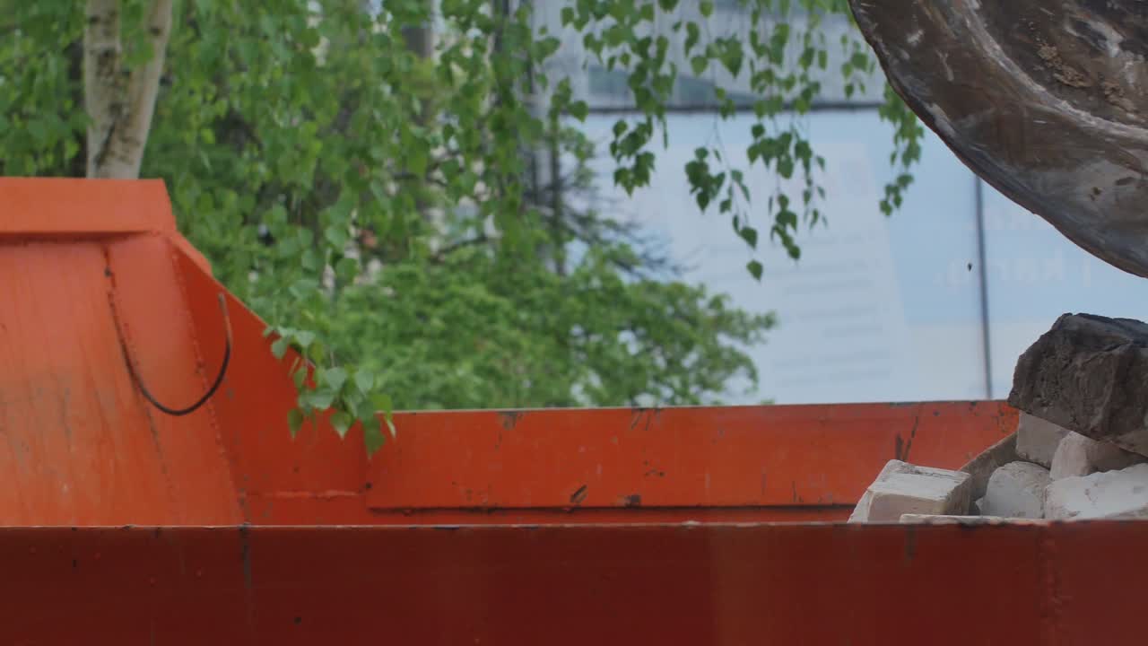 Excavator With Bucket Loads Construction Brick Scrap To The Truck