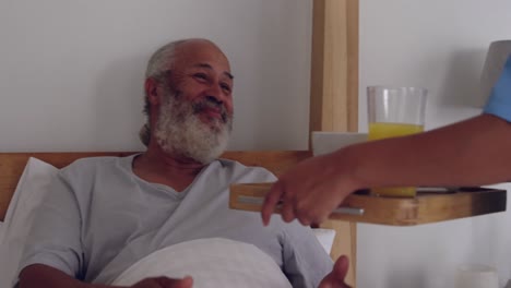 hombre maduro servido comida por una enfermera