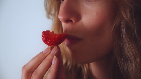 close up of an attractive woman eating strawberry - slow motion