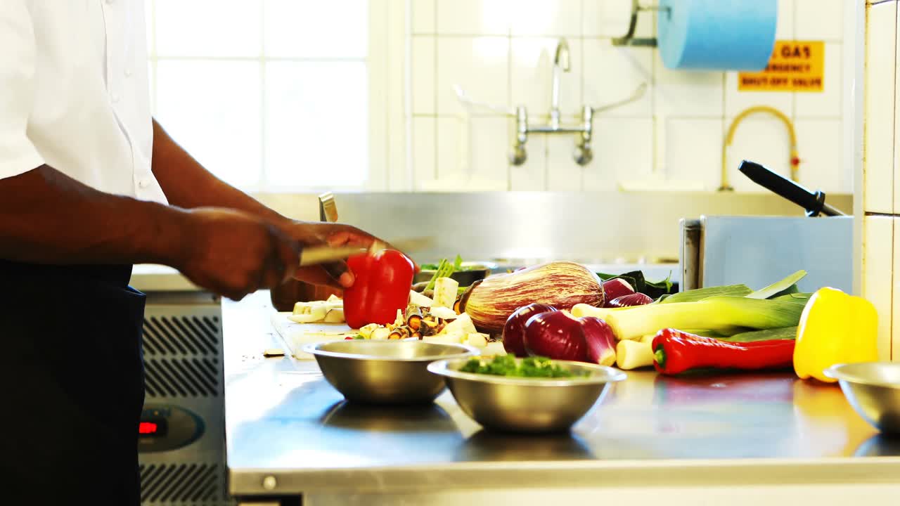 chef cortando verduras en la cocina comercial