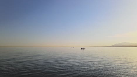 forward aerial movement over the water with boat on the horizon