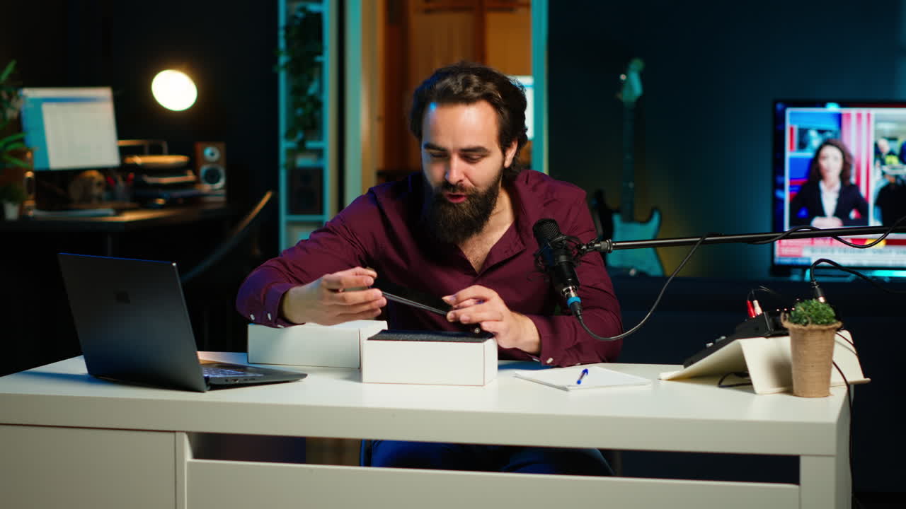 influenciador tecnológico filmando la revisión de un teléfono inteligente recién lanzado, abriéndolo de la caja