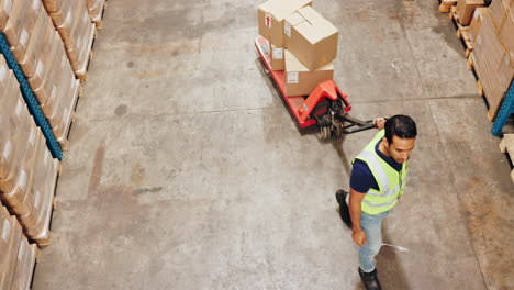 worker moving boxes with a pallet jack in a warehouse