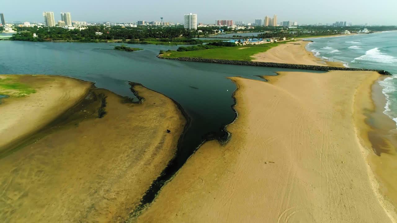 고층 건물을 배경으로 도시 스카이라인을 배경으로 백워터가 열리는 해변의 드론 영상