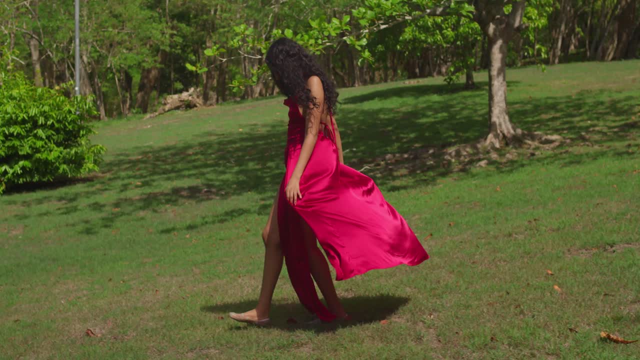 el parque tropical del caribe está vivo con la energía de una joven latina caminando con un vestido rojo.