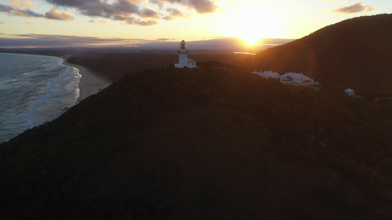 filmación cinematográfica de drones giratorios del amanecer en el faro de smoky cape cerca de south west rocks, kempsey shire, nueva gales del sur, australia