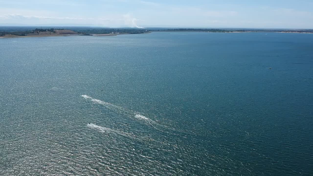 drone alto sobre un lago con lanchas rápidas