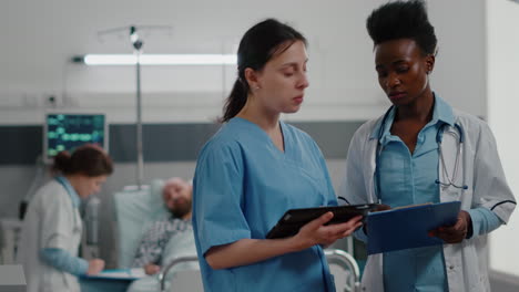 medical nurse showing medical expertise using tablet computer to specialist black doctor woman