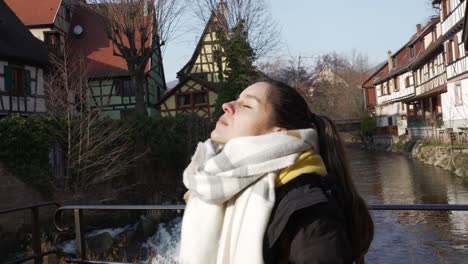 Turista-Disfrutando-De-La-Luz-Del-Sol-Golpeando-Su-Cara-En-Un-Frío-Día-De-Invierno-En-La-Turística-Ciudad-Medieval-De-Kaysersberg