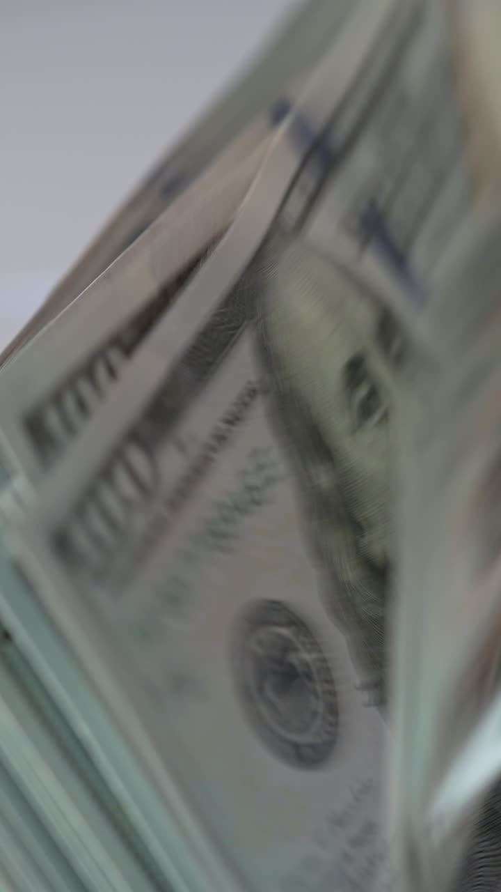 Mechanism in cash counting machine turning quickly. US hundred dollar banknotes counted in the money counting equipment. Close up. Vertical video