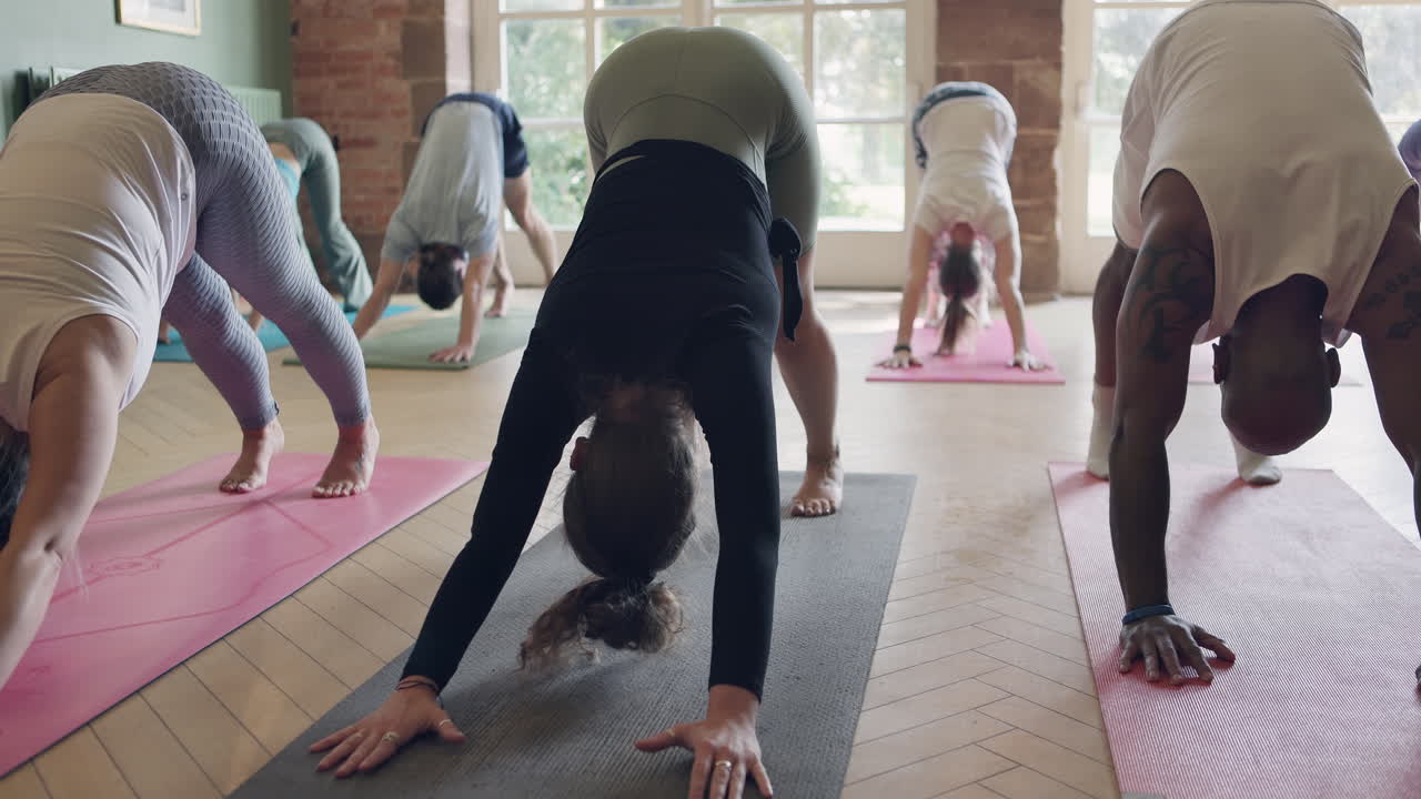 Yoga class practicing downward-facing dog pose