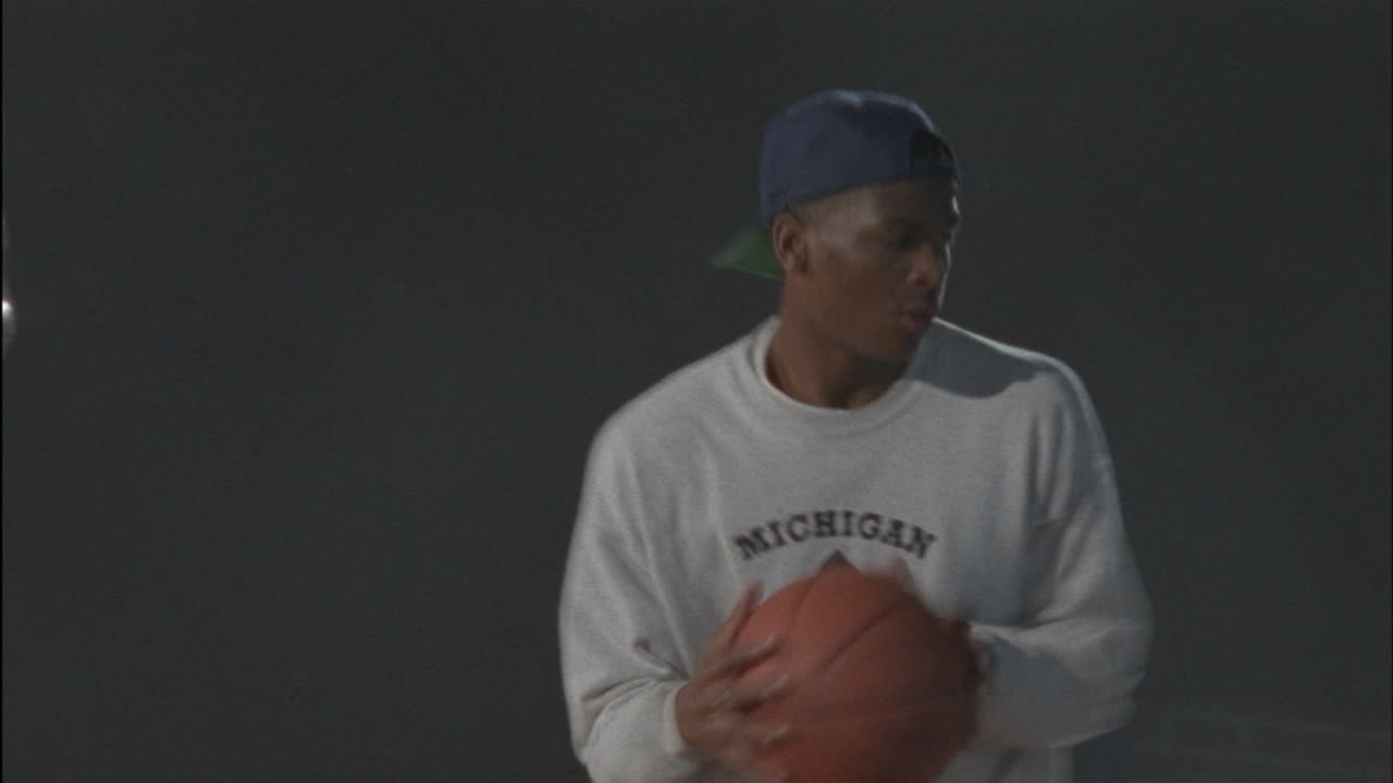 tres hombres corren y hacen rebotar una pelota de baloncesto en un gimnasio