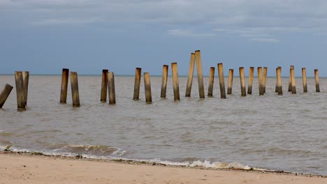 abstract concrete pillars and columns from an old pier along the coastal beach in thailand