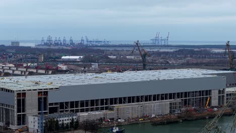 drone aerial establishing of gdansk shipyard with baltic hub container terminal and warehouses, cranes on horizon