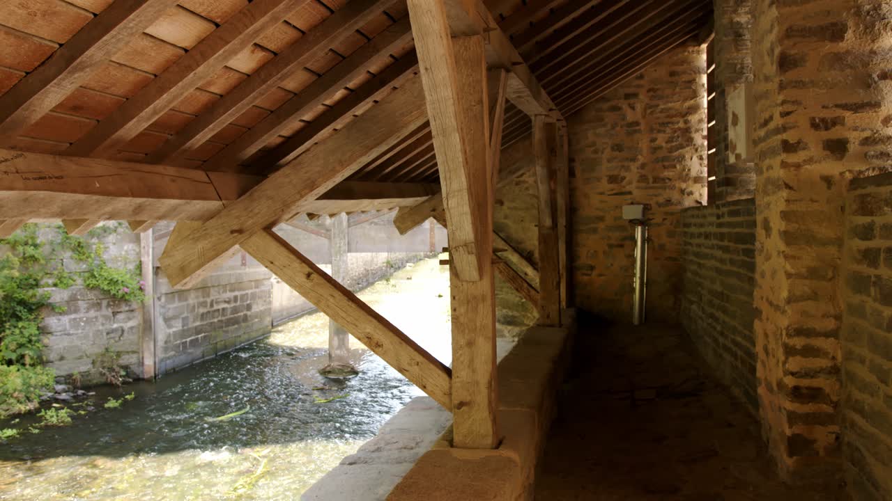 Brick Structure With Wooden Frame Roof By The Flowing River. Sideways Shot