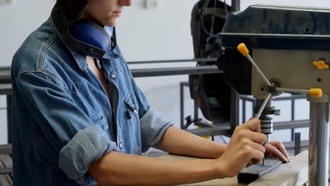 carpenter using vertical drill machine in workshop 4k