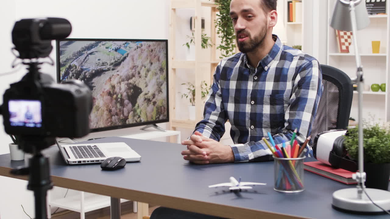 Man filming vlog at desk with paper bag