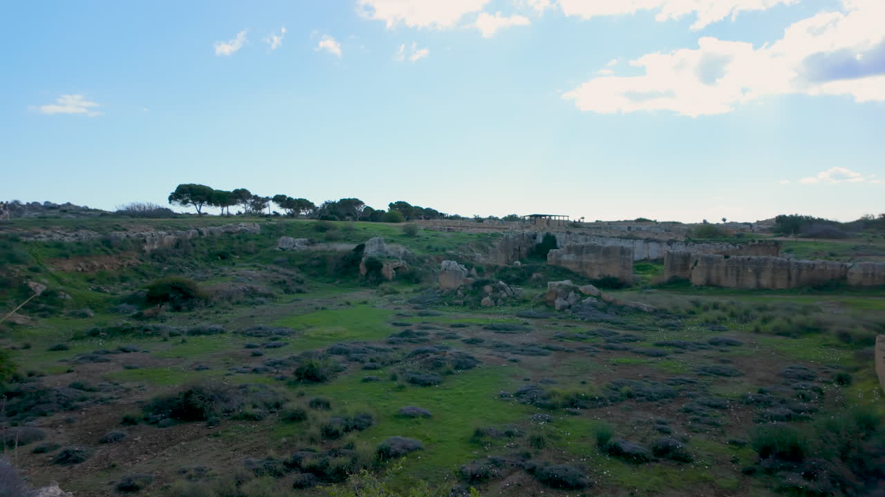vista panorámica de las tumbas de los reyes con las extensas ruinas del sitio que se extienden bajo un cielo dramático, enfatizando la grandeza antigua del sitio